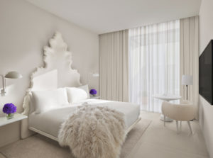 Bright, stylish guest room with fur throw on bed