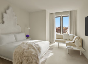 Light-filled guest room with fur throw on bed