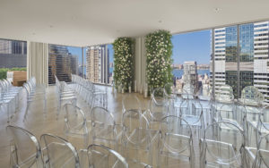 Wedding ceremony arrangement with leucite chairs and city view